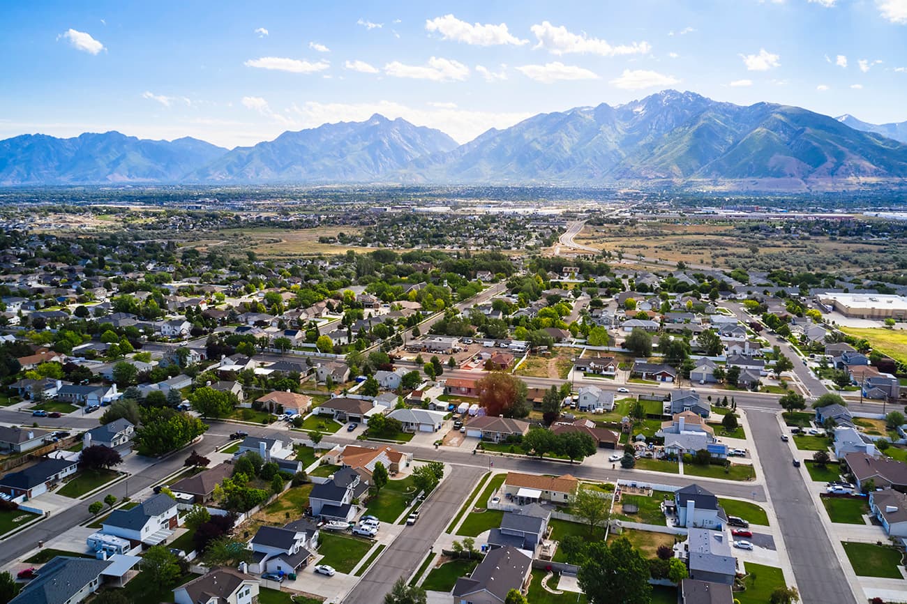 Aerial view of residential neighborhood in Utah with mountains in the background Aerial view of residential neighborhood in Utah with mountains in the background