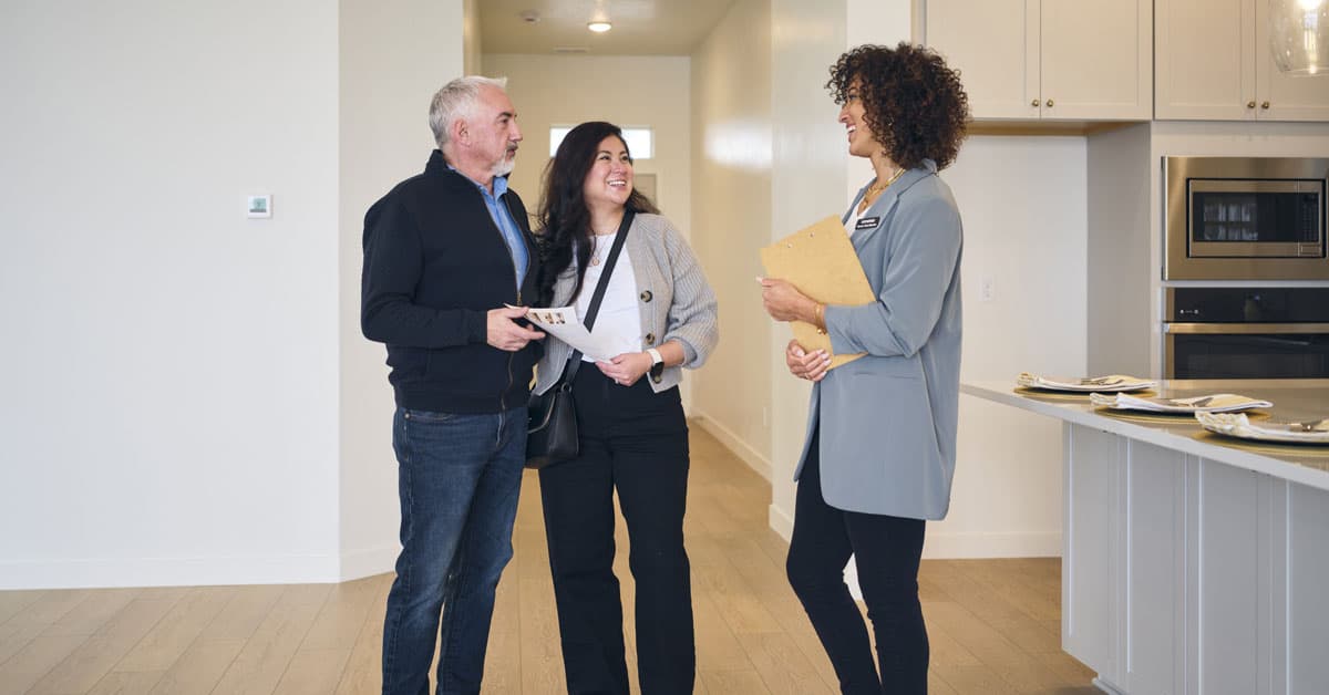 New home construction - real estate agent meets prospective buyers in a modern kitchen