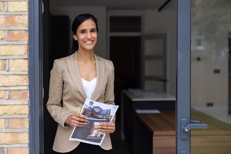 Agent holding listing printout and standing at deck door Agent holding listing printout and standing at deck door