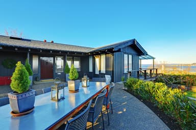 Waterfront house with table and chairs on patio Waterfront house with table and chairs on patio