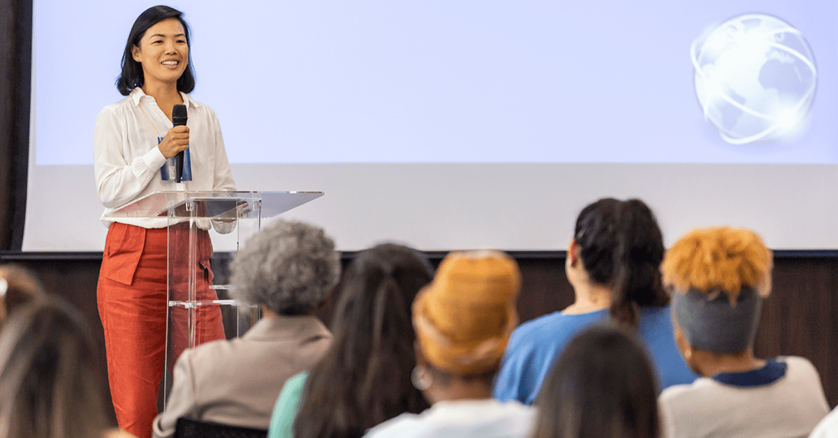 An Asian Woman at a Podium Lecturing at a Conference Representing New York State Association of REALTORS® Fall Business Meetings