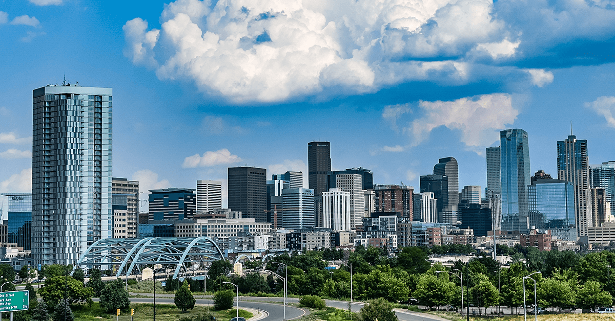 The Downtown Denver, CO Skyline with a Bright Blue Cloudy Sky Representing Signal by 100WATT