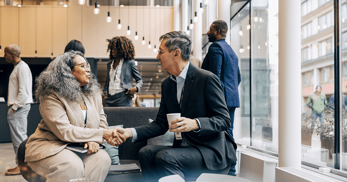 Two Businesspeople on an Office Couch Shaking Hands Representing the Texas REALTORS® Association Deep Dive in Austin, TX