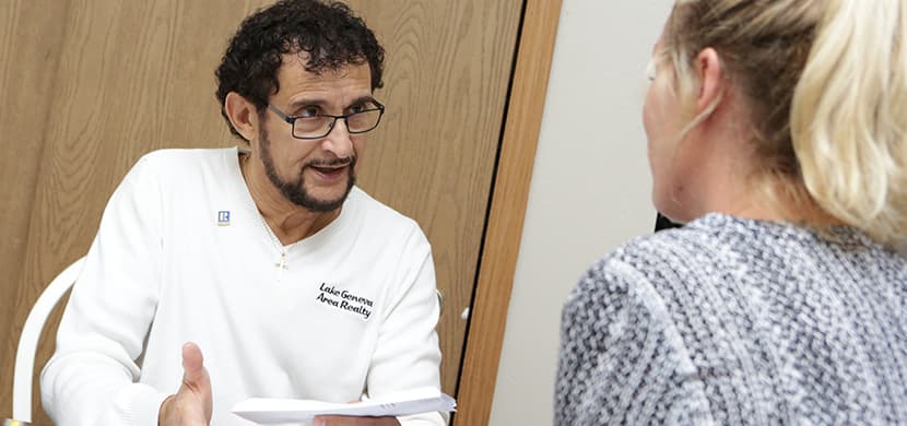 Man consulting with woman at table. Dimiceli
