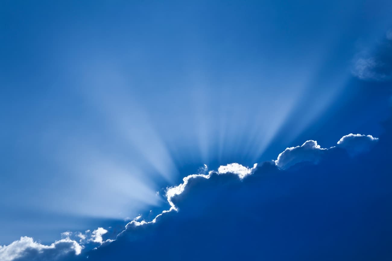 Sun rays peeking out from behind clouds, exemplifying hope