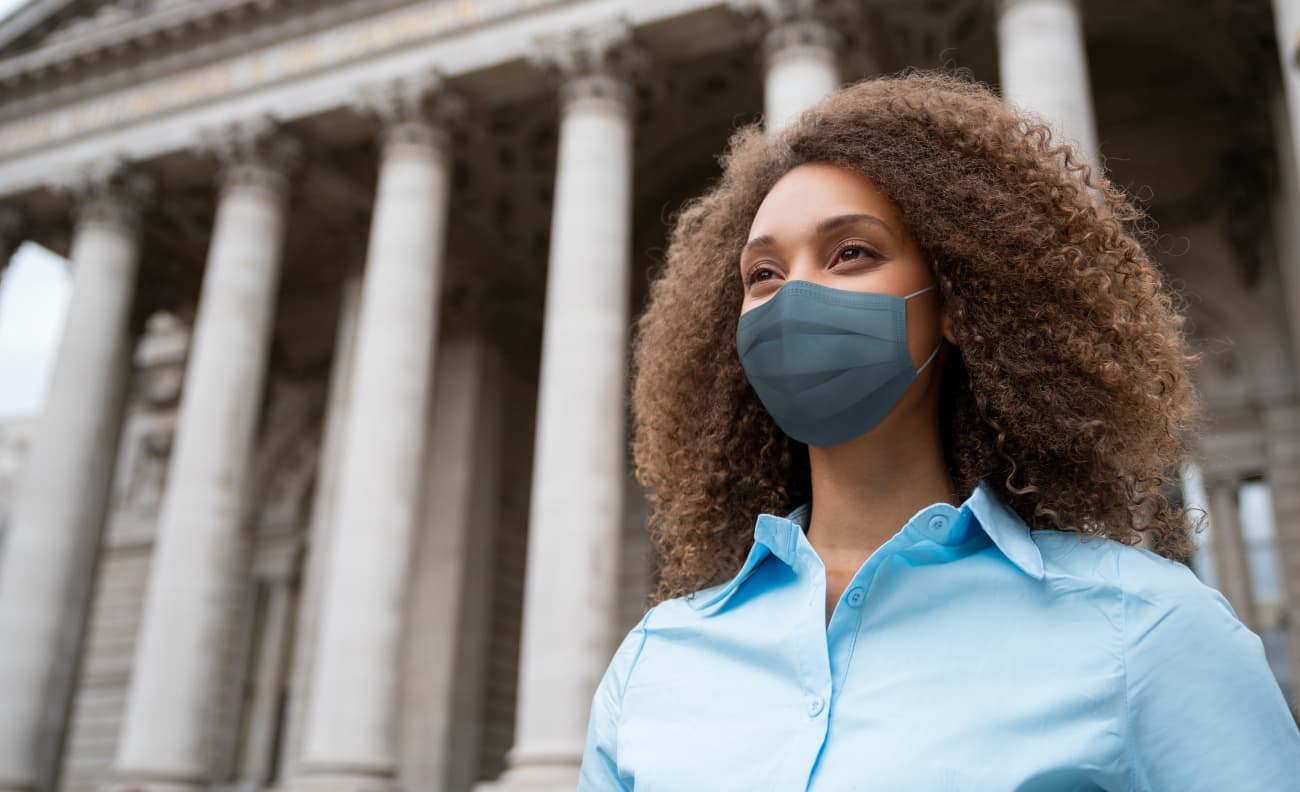 business woman wearing mask outside of a courthouse