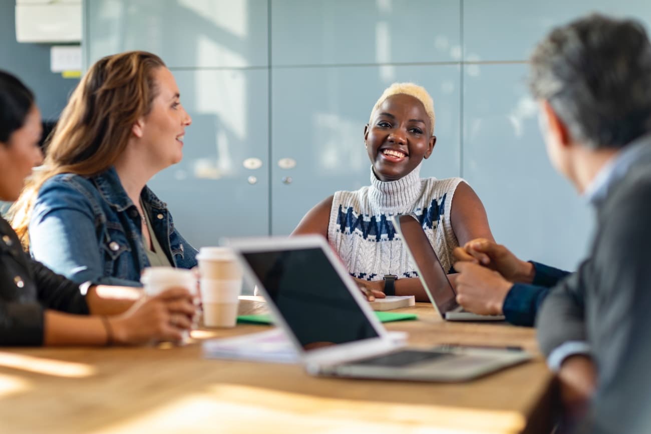 Cheerful business colleagues in meeting discussing project