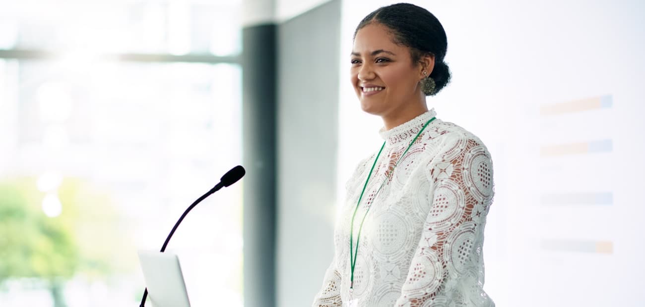Smiling business woman standing at podium