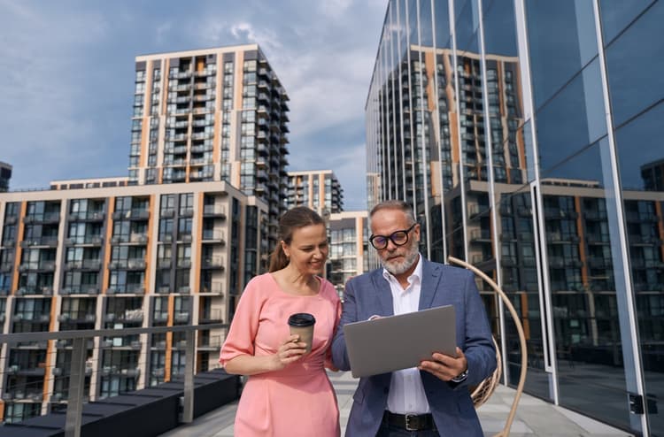 two colleagues collaborating in urban area with laptop