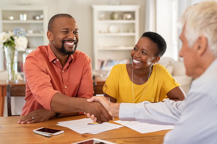 Man with white hair with clients, shaking hands Man with white hair with clients, shaking hands