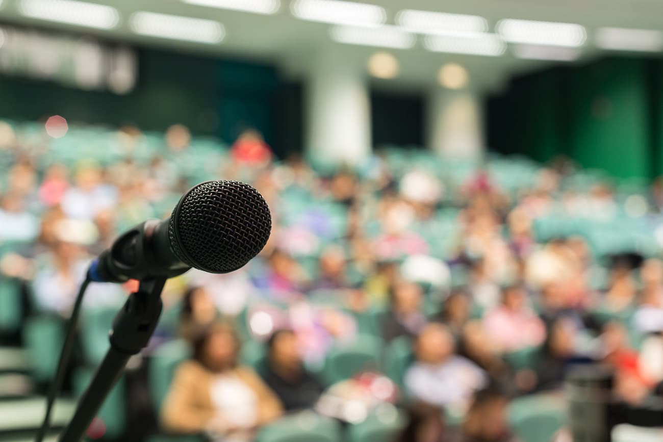 Microphone with convention attendees in the background Microphone with convention attendees in the background