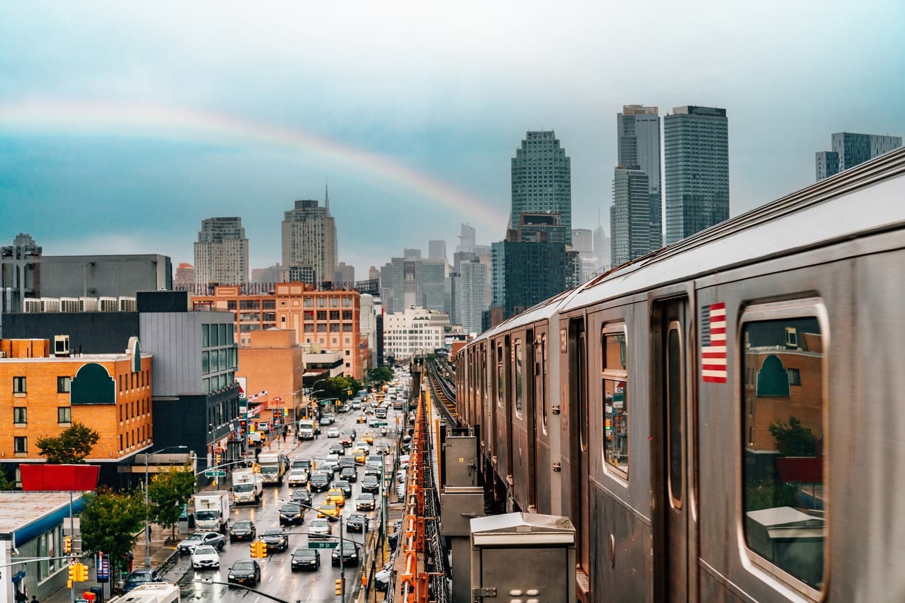 New York City subway train is approaching an elevated subway station in Queens