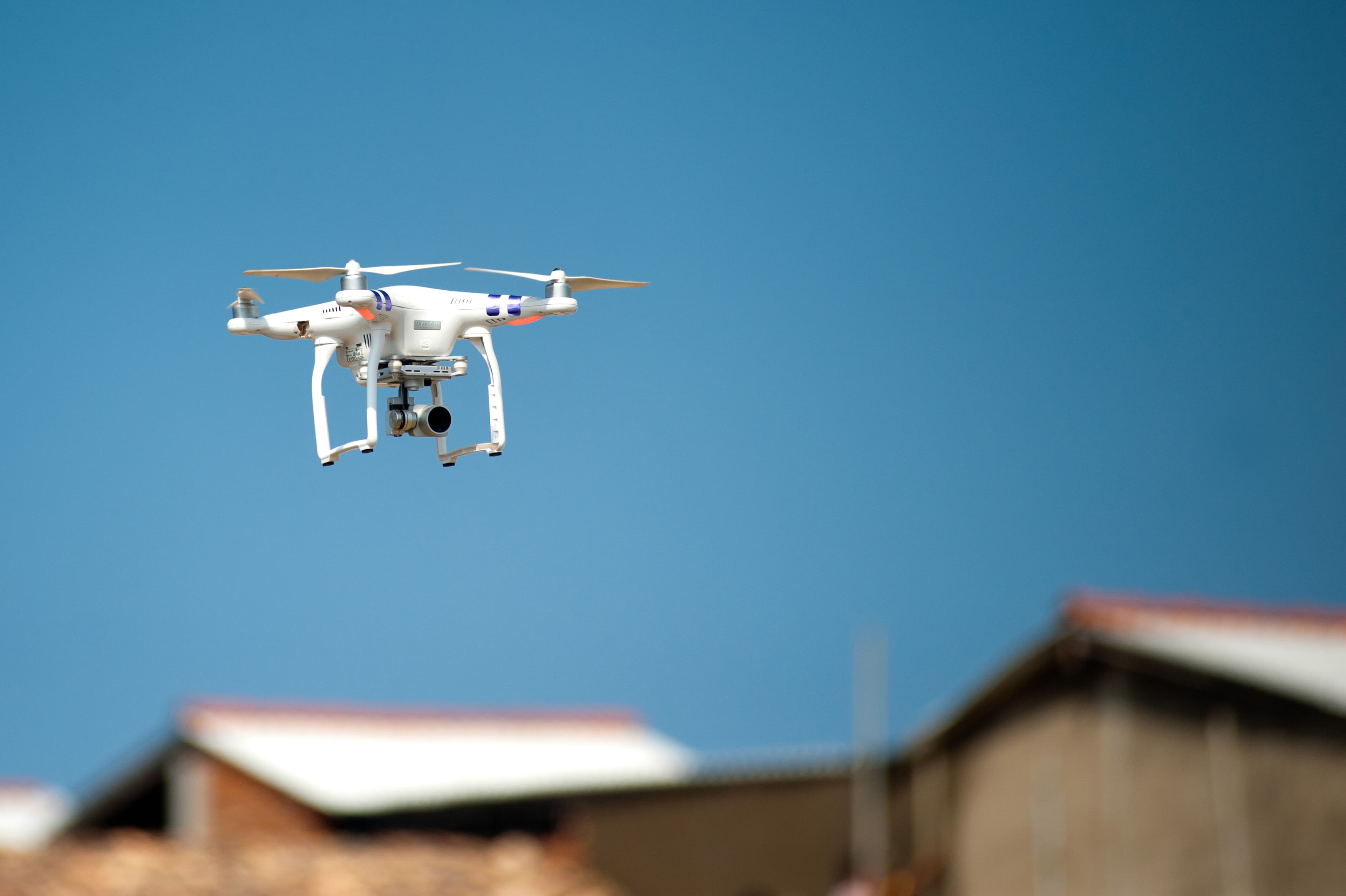drone flies over rooftops