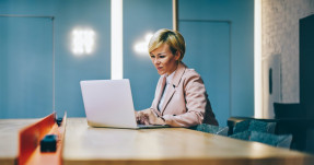 Blond woman working at laptop