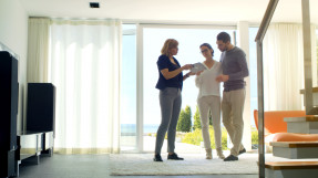 Agent showing a couple a bright, sunny living room, window to the law, reduce the risk of misrepresentation