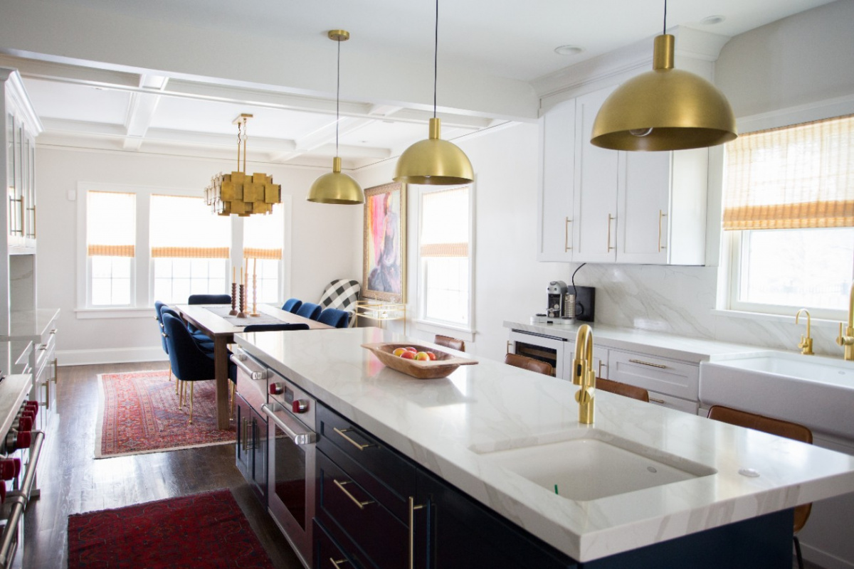 White countertop kitchen island with gold metal pendant lamps