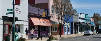 A street view showing a Thai food restaurant, a boutique shop, a vision center, and other small businesses