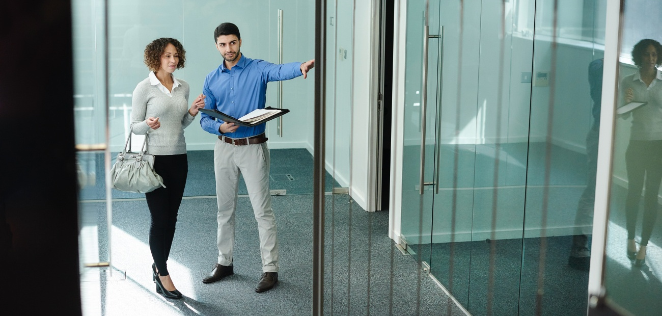 business woman viewing empty office space with real estate agent