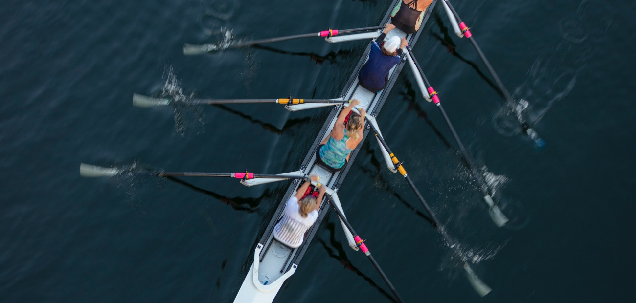 Overhead view of three people rowing a boat