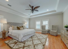 Bedroom with ceiling lights, windows on all sides and floor lamp