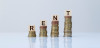 Four stacks of coins from left to right growing taller with wooden letter pieces atop each one, spelling "RENT"