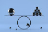 Balance board on blue background with chrome spheres