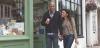 Couple walking along shopping district street