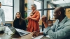 Diverse businesspeople smiling during office meeting risk management impact of DEI
