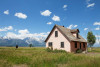 Farm house in open field with mountains in the distance
