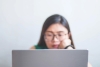 Woman in glasses working on laptop computer
