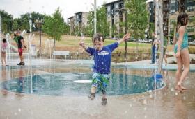 boy splashing through fountain